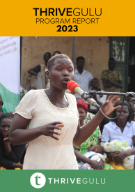 Young woman speaks into a microphone, surrounded by listeners.